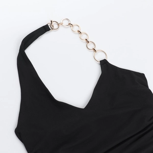 Détail du haut dos nu noir avec décolleté en V profond et anneaux en métal doré