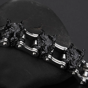 Detail of the black wolf head sculpture and silver bike chain link on punk bracelet