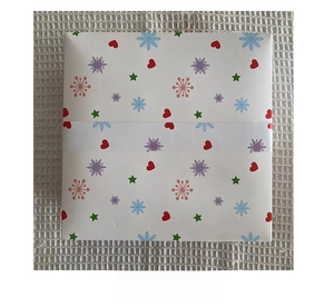 Detailansicht der Geschenkbox-Rückseite mit festlichen roten Herzen und grünen Sternen