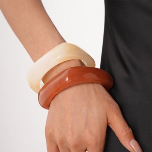 Vintage resin geometric bangles in cream and amber brown on a model's wrist
