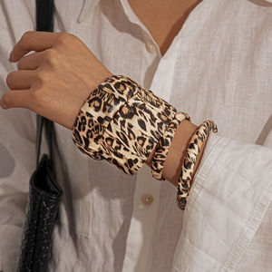 Close-up of leopard print cuff bracelets in varying widths on a woman's wrist