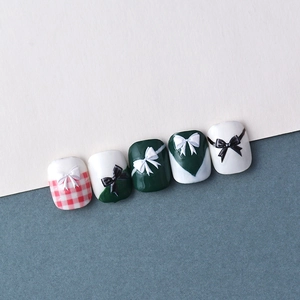 Macro view of 5D embossed nail art stickers with 3D bows and red plaid patterns