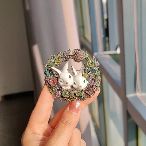 Detailed view of vintage rabbit brooch featuring colorful rhinestones and enamel flowers