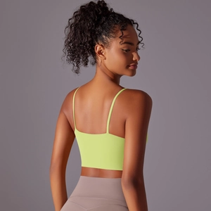 Rear view of neon yellow yoga top with thin straps and elastic back structure on model