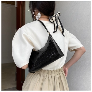 Detail of black faux crocodile leather texture on a chic shoulder bag for women