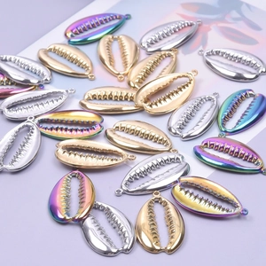 Macro view of shell-shaped stainless steel pendants in gold, silver, and rainbow colors