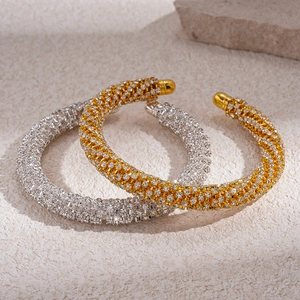Bracelets luxueux en or et argent avec cristaux scintillants sur une surface en pierre