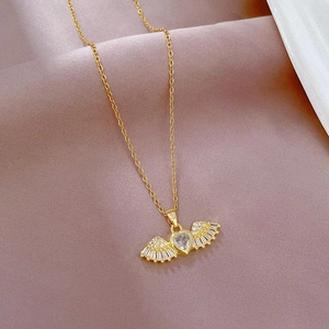 Gold angel wing heart pendant necklace with zircon on purple velvet background