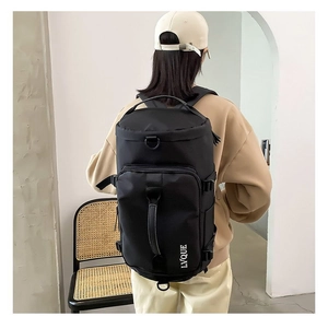 Close-up of black cylindrical travel backpack with durable handles and sport D-rings