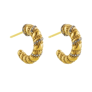 Macro shot of gold plated C-shaped twisted earrings with sparkling white cubic zirconia