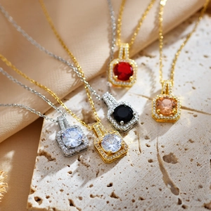 Macro shot of square zircon pendants in gold and silver finish on stone and satin