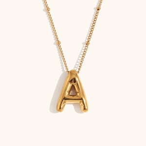 Detailed shot of 18K gold plated bubble letter A pendant with sunburst texture