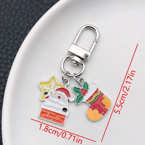 Detail of Christmas keychain with Santa and snowflake charms on a white ceramic plate