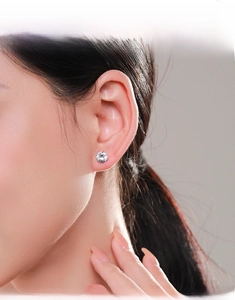 Primo piano di orecchino a perno in argento S925 con zircone indossato da una modella