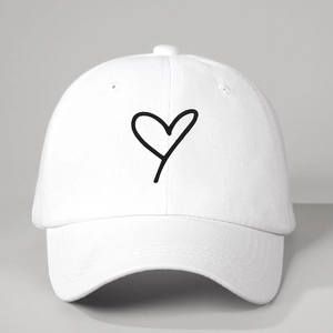 Minimalist white cotton baseball cap with a black hand-drawn heart pattern and curved brim
