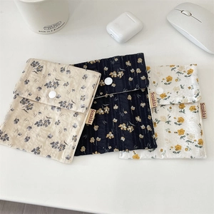 Set of three floral fabric pouches with snap button closure shown on a white desk