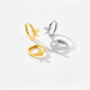 Macro shot of silver and gold hummingbird earrings on a clean white backdrop