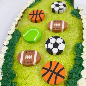 Macro detail of sports-themed erasers featuring football, basketball, and tennis balls
