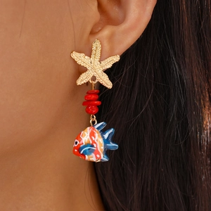 Detailed view of sea style earrings with starfish and colorful small fish on model