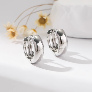 Polished wide silver hoop earrings for women with minimalist floral background
