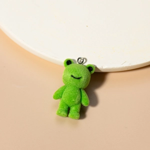 Macro view of green flocked frog pendant with a metal ring and soft plush texture