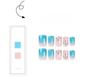 Detail of short square press-on nails with blue glitter gradients and dried flower accents