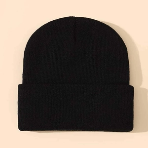Close-up of black ribbed knit beanie showing dense texture and wide folded cuff detail