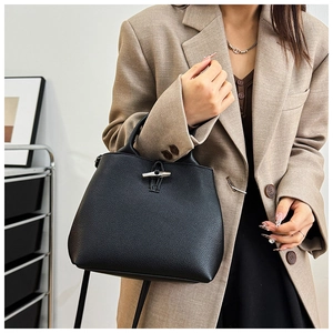 Detailed view of black pebbled leather handbag with signature bamboo-shaped metal buckle