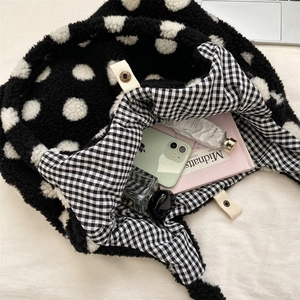 Intérieur spacieux du sac seau en peluche à pois avec doublure vichy et bouton pression