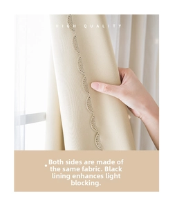 Detail of beige blackout curtain with delicate butterfly embroidery and thick fabric