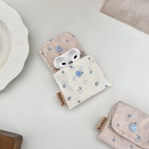 Detail of floral canvas storage pouch with snap button and brown side brand label