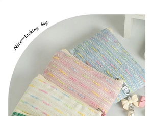 Detail of fabric cosmetic bags with dotted texture and decorative bow pearl pendant