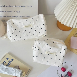 Detail of striped heart pattern travel cosmetic bags with soft cotton texture and zipper