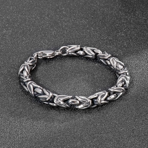 Detailed view of silver steel Byzantine link chain bracelet with lobster clasp on black background