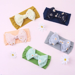 Detailed view of baby nylon headbands with embroidered daisy mesh bows in various colors