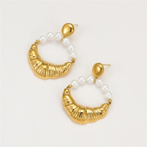 Macro detail of gold horn-shaped earrings featuring polished finish and white pearl inlay