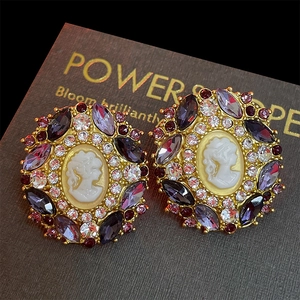 Detail of vintage cameo earrings with purple crystals and sparkling rhinestones