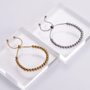 Detail of adjustable stainless steel bead bracelets in gold and silver finishes