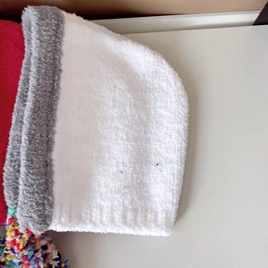 Detailed close-up of soft white fleece fabric with colorful tassels on winter hat
