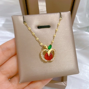Luxurious gold hollow apple pendant necklace with red crystal and sparkling zirconia accents