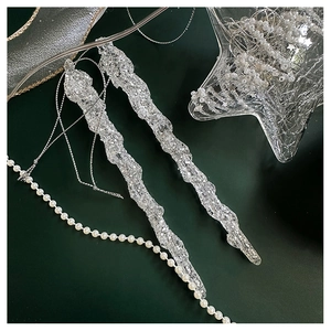 Close-up of clear icicle Christmas ornaments with icy texture and silver hanging string