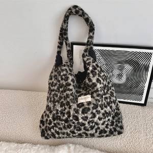 Detail of leopard print faux shearling tote bag with brand label and plush texture