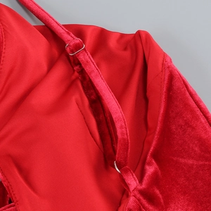Détail d'une robe en velours rouge avec de fines bretelles réglables et boucles en métal