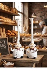 Close-up of two creative resin chef figurines holding desserts for restaurant table decor