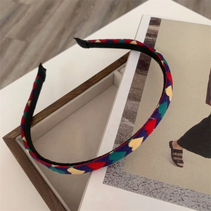 Detail of colorful plaid fabric headband with red yellow and green diamond patterns