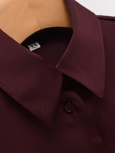 Detailed view of burgundy satin shirt collar with buttons and size label