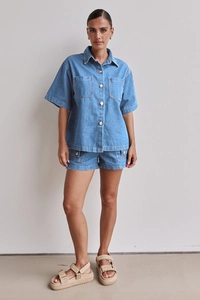 Detail eines blauen Denim-Zweiteilers mit Kurzarmhemd und passenden kurzen Shorts