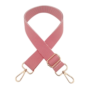 Close-up of red and white striped woven bag strap with golden metal swivel hooks