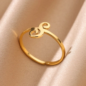 Close-up of polished gold adjustable ring with minimalist S-curve letter design