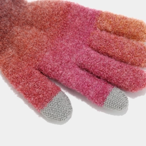 Detail of gradient pink knit gloves with touch screen fingertips and thick fiber texture
